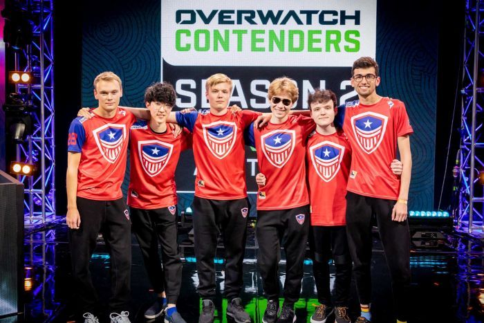 Overwatch League takımı Washington Justice, Melbourne Esports Open'da bir fotoğraf çekmek için kolları birbirlerinin etrafında durdu.